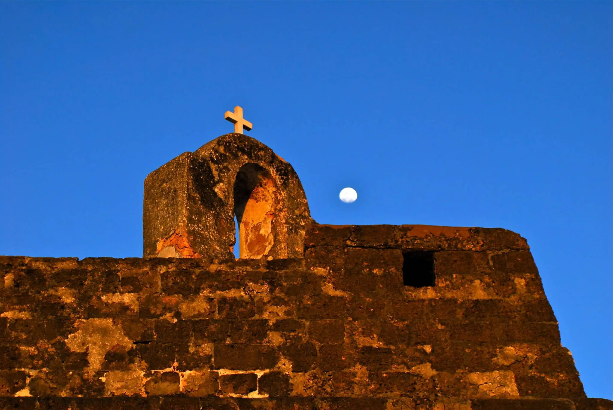 un mur en pierre de la forteresse de san sebastian de nuit avec lune