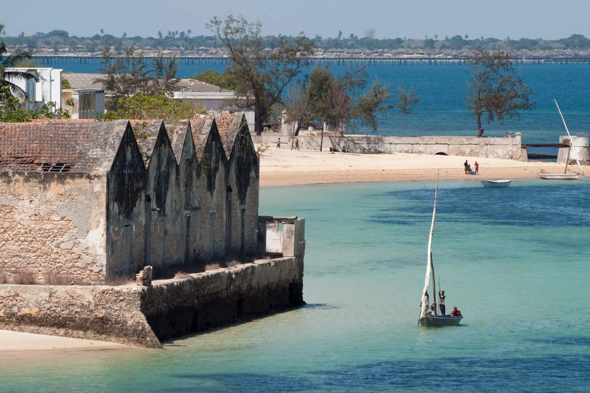 un boutre sur l'eau turquoise approche du rivage de l’île de mozambique