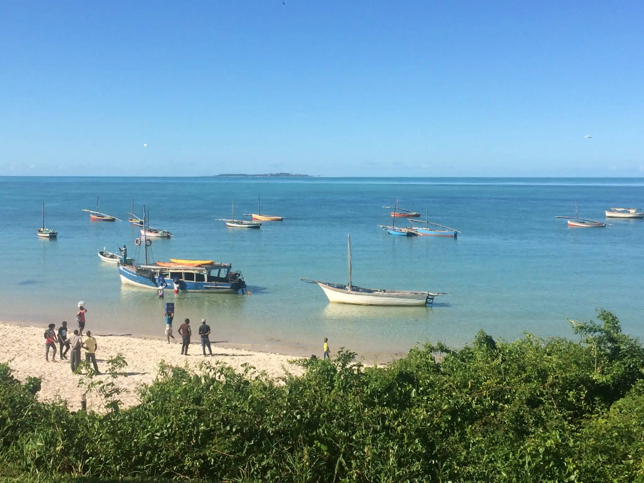 bateaux de pêcheurs et enfants rassemblés sur les rives de la plage