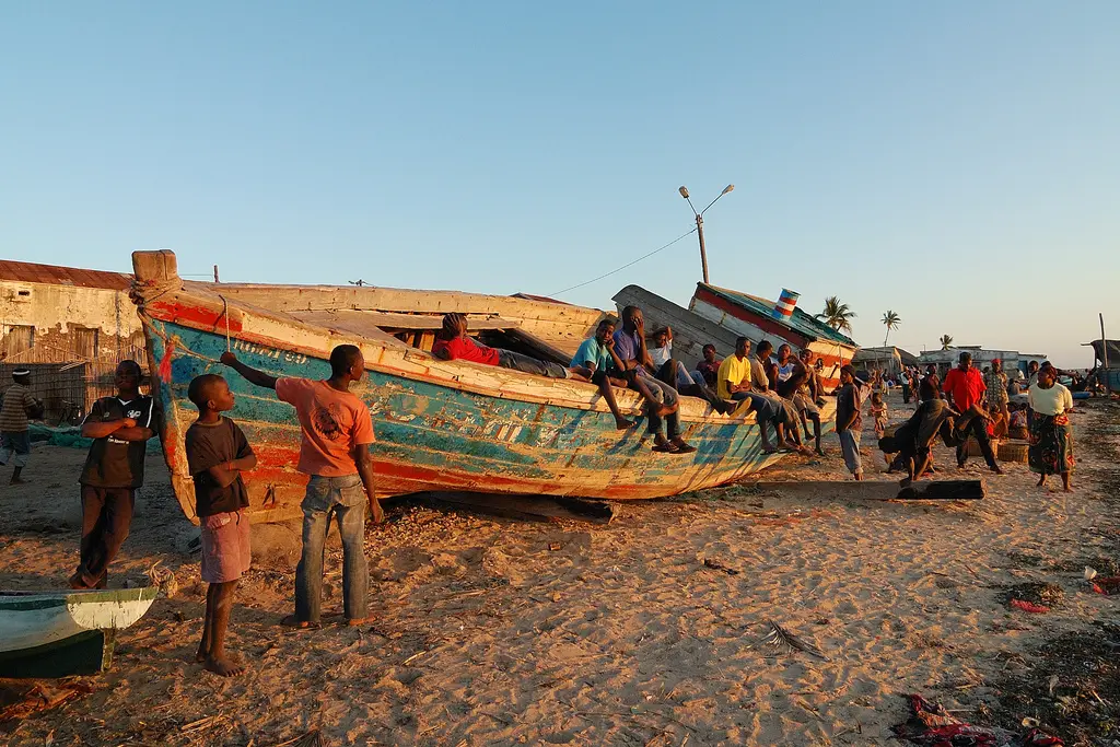 des enfants mozambicains se détendent sur un bateau coloré sur la plage