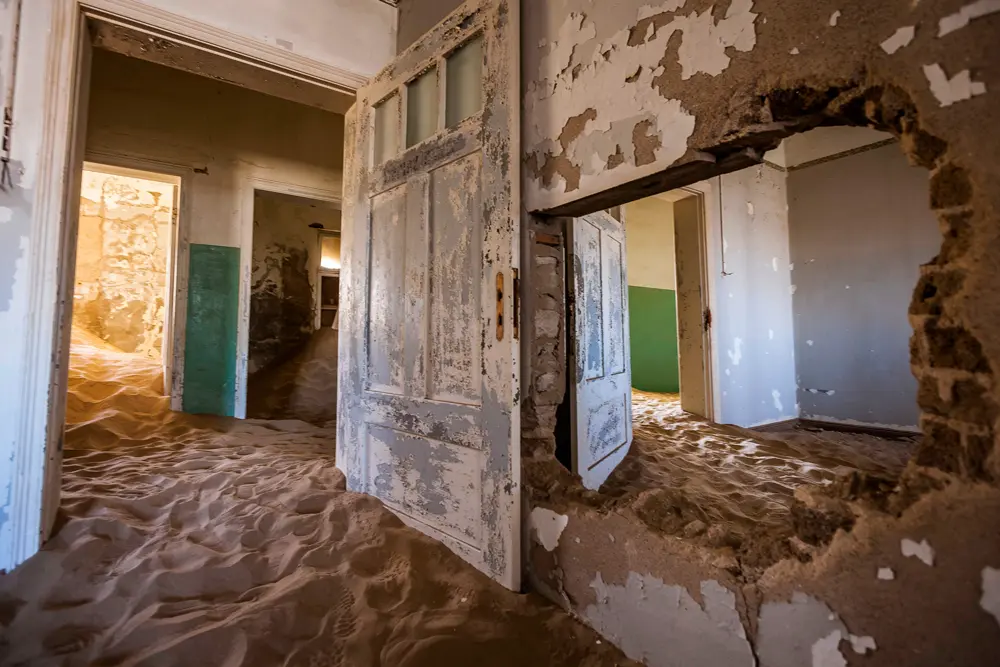 L'intérieur d'un vieux bâtiment avec ses portes ouvertes et ensablées