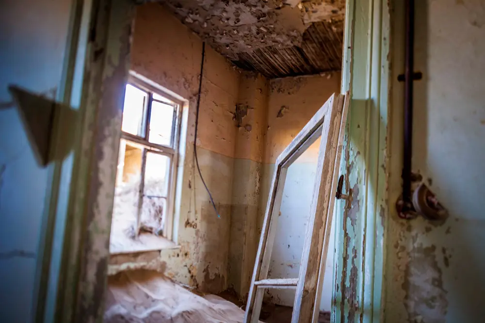 L'intérieur d'un bâtiment de Kolmanskop enseveli par le sable du Namib