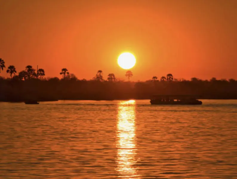 Croisière sur le Zambèze avec un ciel orange et rouge