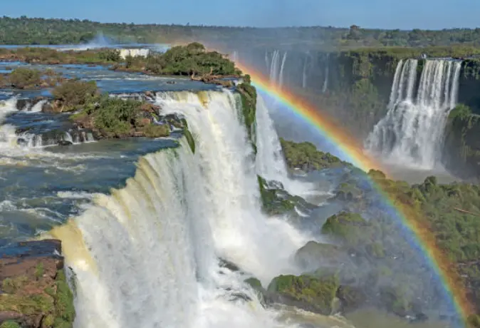 De profil, vue sur la puissance des chutes d'eau avec un arc en ciel