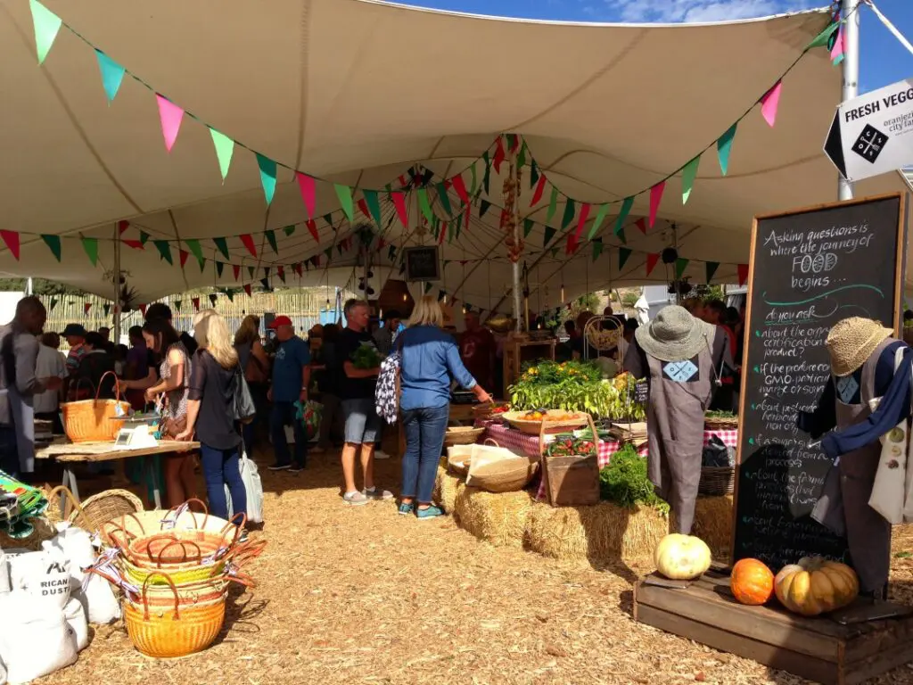 Personnes marchants dans les allées du marché bio d'Oranjezicht
