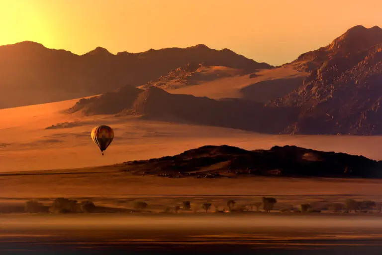 Une montgolfière au dessus de la région du Namib au coucher du soleil
