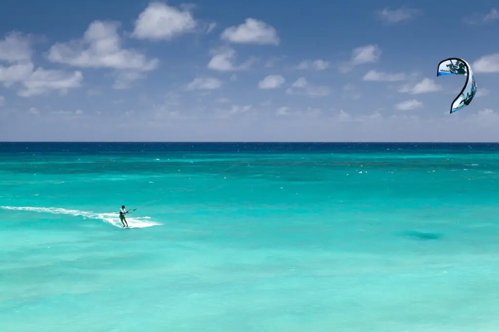 Seul au milieu des eaux turquoise un homme pratique le kitesurf