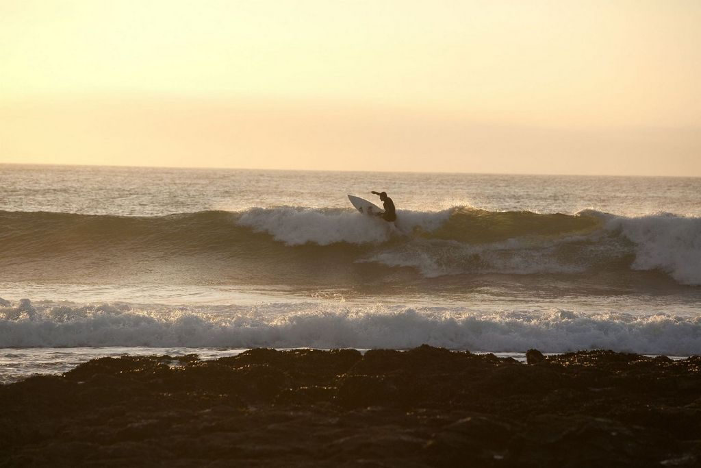 Surfeur maitrisant la vague de Jeffrey's Bay sous le soleil couchant d'Afrique du Sud