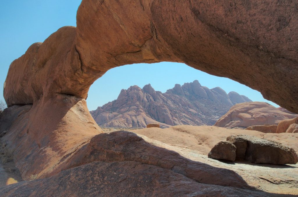 L'arche en forme d'oeil de Spitzkoppe avec en fond les montagnes