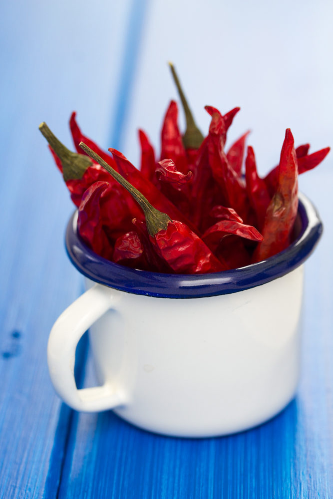 Tasse métallique remplie de piment peri peri rouges séchés
