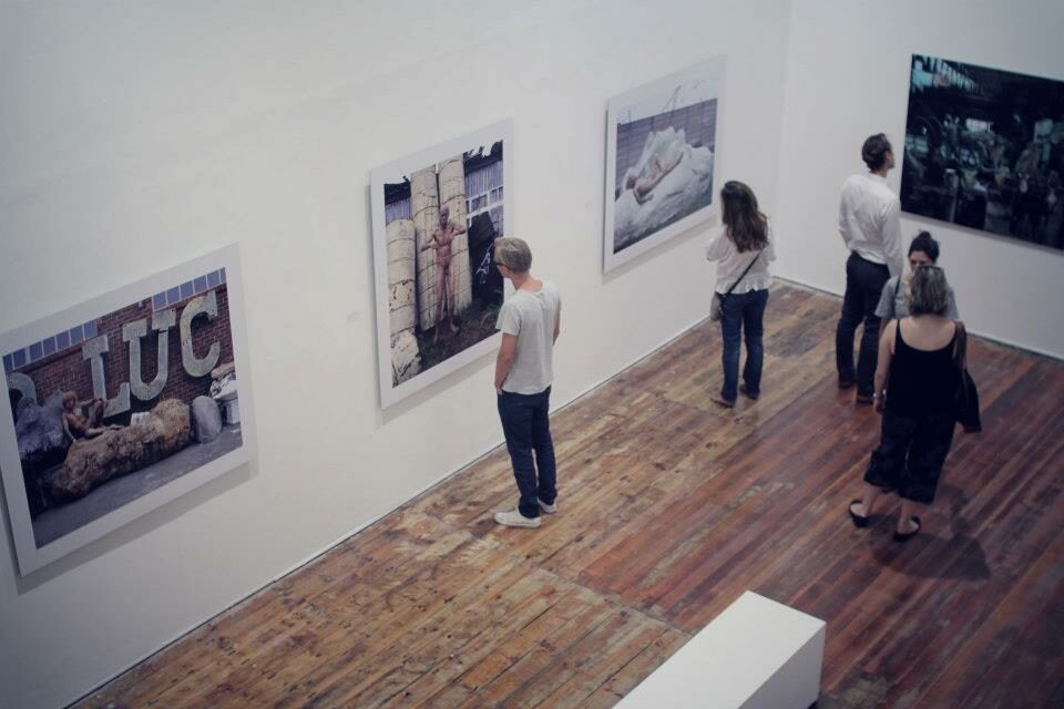 Quatre personnes observent des tableaux dans une galerie d'art