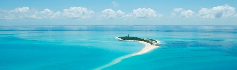 Décor paradisiaque avec une ile isolée au milieu des eaux turquoise
